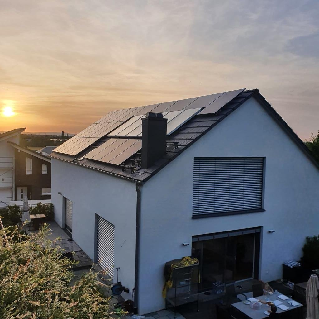 Einfamilienhaus mit Photovoltaik-Anlage auf dem Satteldach im Abendlicht